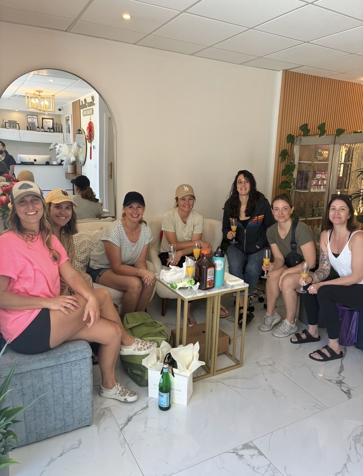 Seven friends from Long Beach celebrating Katie's birthday with mimosas at Lavie Bella Head Spa in Artesia